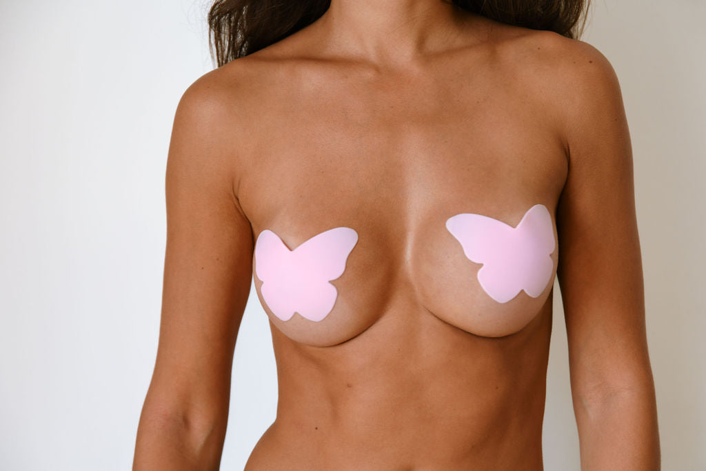 "Light pink butterfly-shaped silicone nipple cover for discreet, stylish, and comfortable coverage. Reusable and ultra-thin for confident fashion."