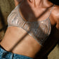 Woman in sparkly bra and jeans with nude circular nipple covers